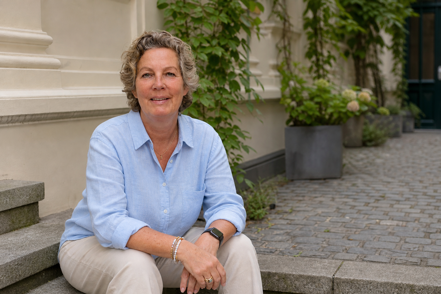 Susanne Lentz-Pesch sitzt auf einer Steintreppe im Hof